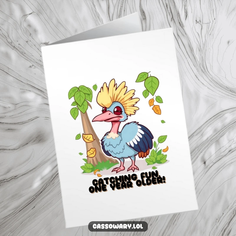 Funny free printable birthday card shows a cassowary making a ridiculous face while attempting to catch a falling autumn leaf.