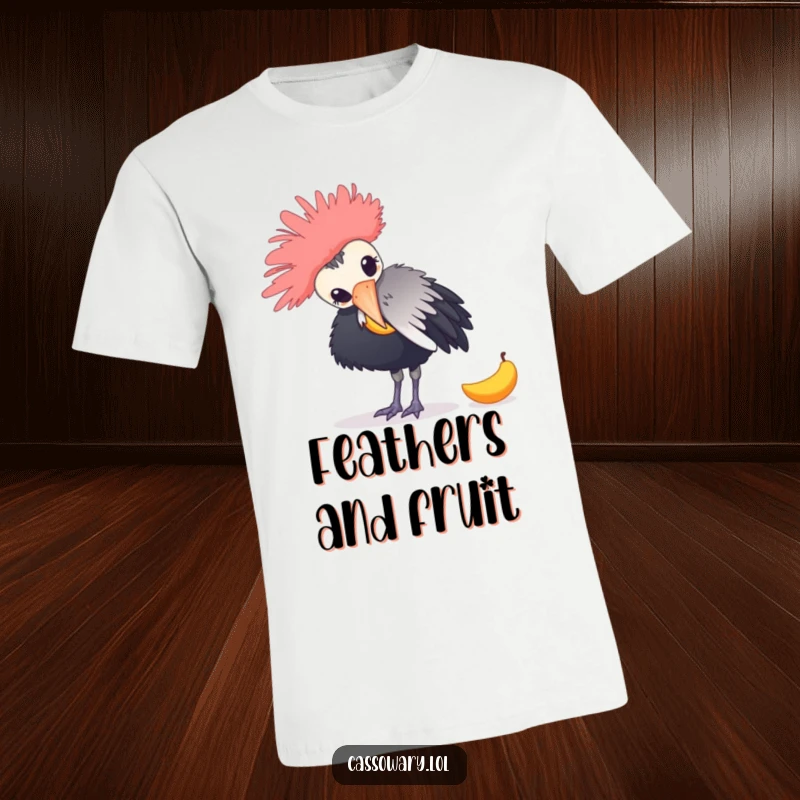 Funny t-shirt graphic of a cassowary playfully nudging a fallen mango with its beak, highlighting avian antics and humor.